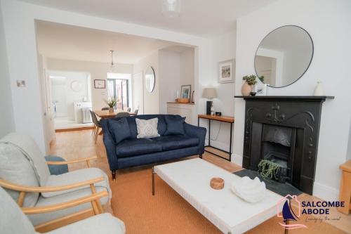 a living room with a blue couch and a fireplace at Stylish Coastal 3 Bed Haven - Close to town in Salcombe
