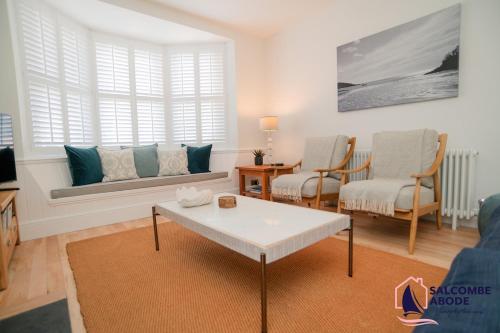 a living room with a couch and a table at Stylish Coastal 3 Bed Haven - Close to town in Salcombe