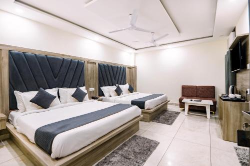 a hotel room with two beds and a television at Hotel The Katra Avenue in Katra