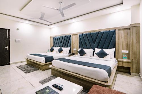 two beds in a hotel room with sidx sidx sidx sidx at Hotel The Katra Avenue in Katra