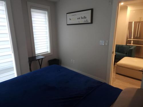 バンクーバーにあるmetropolitan 2-Bedroom condo Oak stのベッドルーム(青いベッド1台付)、リビングルーム