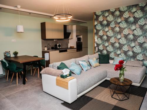 een woonkamer en keuken met een bank en een tafel bij Balance Apartman Debrecen in Debrecen