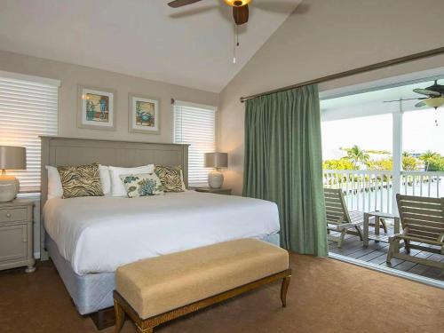 a bedroom with a large bed and a balcony at Hawks Cay Resort in Marathon