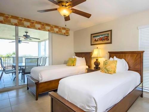 two beds in a room with a balcony at Hawks Cay Resort in Marathon