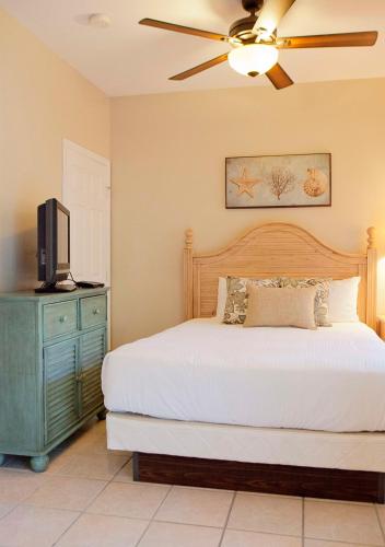 a bedroom with a bed with a ceiling fan and a tv at Hawks Cay Resort in Marathon