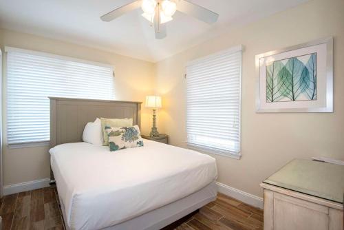a bedroom with a bed with a ceiling fan and windows at Hawks Cay Resort in Marathon
