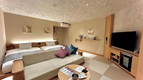 a living room with a couch and a flat screen tv at Hotel Miyama in Chichibu