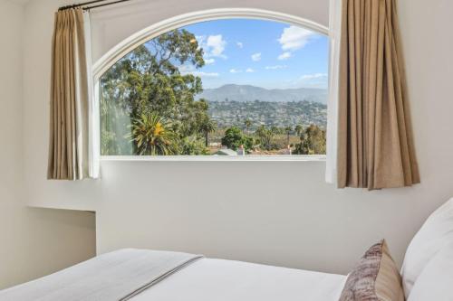a bedroom with a large window with a view at Casa Riviera - Boutique Apartments in Downtown Santa Barbara in Santa Barbara