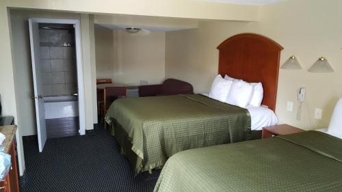a hotel room with two beds and a window at Royal Inn in Tonawanda
