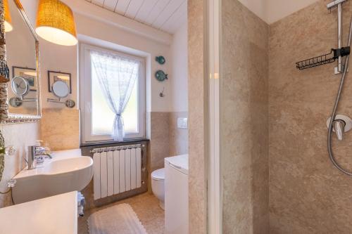 a bathroom with a sink and a toilet and a window at Villa Valentina in Levanto