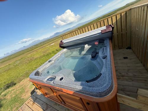 a hot tub sitting on top of a deck at Lindarhóll Guesthouse in Stóri-Bakki