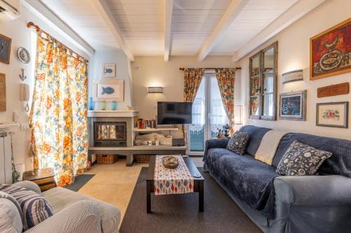 a living room with a blue couch and a tv at Villa Valentina in Levanto