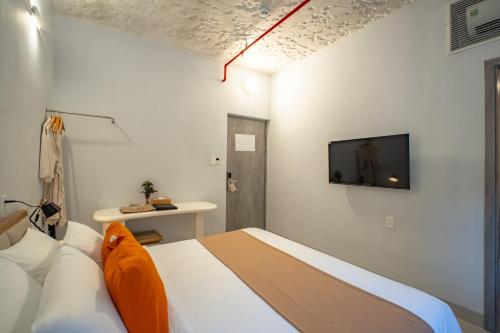 a bedroom with a bed and a tv on the wall at The Up Hotel Phu Quoc Island - The Poolside Escape in Phu Quoc
