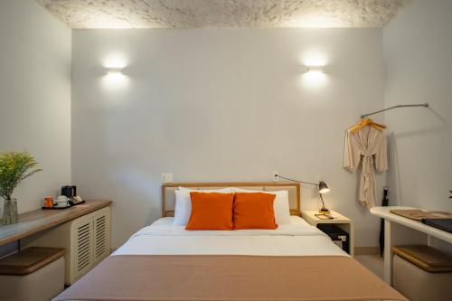 a bedroom with a bed with orange pillows at The Up Hotel Phu Quoc Island - The Poolside Escape in Phu Quoc