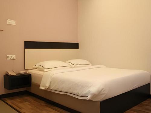 a bedroom with a large bed with white sheets at e Hotel in Melaka