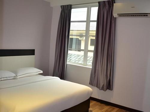 a bedroom with a bed and a window at e Hotel in Melaka