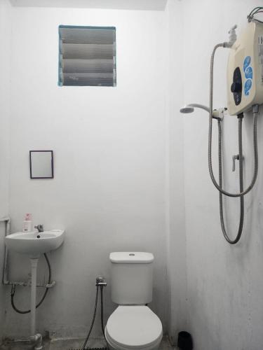 a bathroom with a toilet and a sink at Homestay Zaishazali in Gelugor