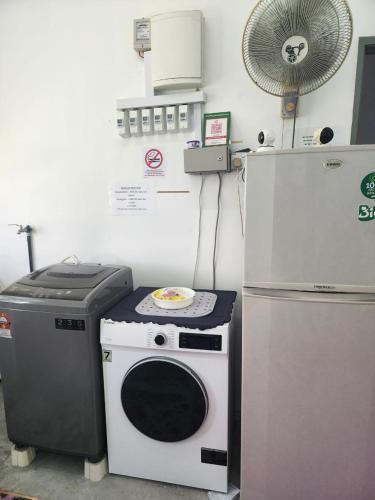 a kitchen with a microwave and a refrigerator at Homestay Zaishazali in Gelugor