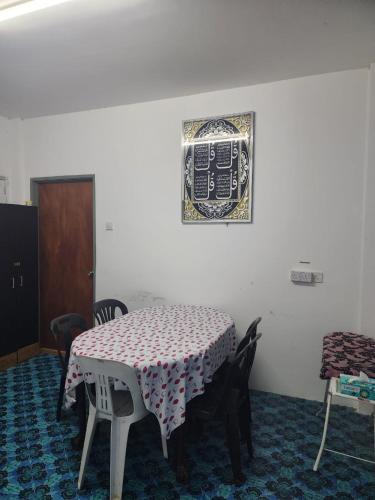 a room with a table and chairs and a picture on the wall at Homestay Zaishazali in Gelugor