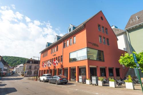 a red building with cars parked in front of it at Gasthof Mühle in Aesch
