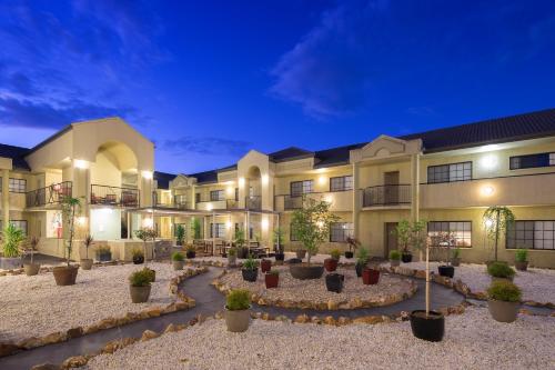 a building with a courtyard with potted plants at Canberra Parklands Central Apartment Hotel Official in Canberra