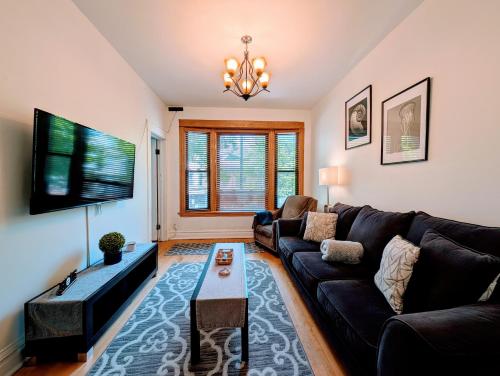a living room with a couch and a tv at The Roscoe Village Guesthouse in Chicago