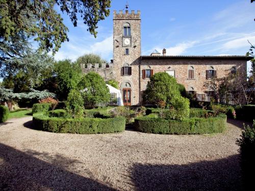 Un edificio antiguo con una torre de reloj y arbustos. en Pleasant Apartment with Swimming Pool,Garden,BBQ, Parking, en Lucolena in Chianti
