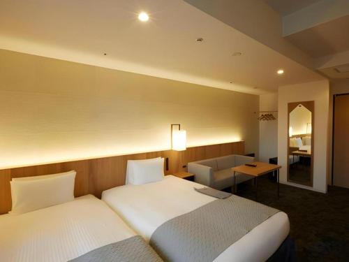 a hotel room with two beds and a desk at HOTEL CLAD in Fuji