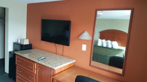 a hotel room with a bed and a mirror at Royal Inn in Tonawanda