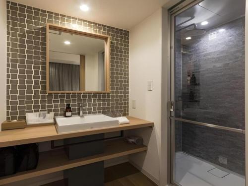 a bathroom with a sink and a shower at HOTEL CLAD in Fuji