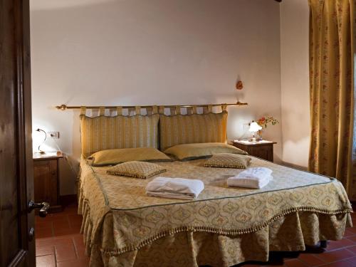 Un dormitorio con una cama con dos toallas encima. en Pleasant Apartment with Swimming Pool,Garden,BBQ, Parking, en Lucolena in Chianti