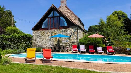a group of chairs and umbrellas next to a pool at The Farmhouse La Drutière in Saint-Sauveur-de-Carrouges