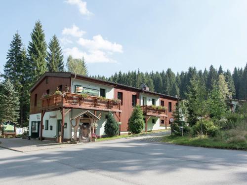 un gran edificio rojo con un balcón en una calle en Luxurious Apartment in Jägersgrün with Saunas, en Jägersgrün