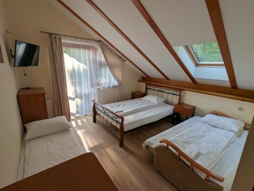 a attic room with two beds and a window at Pokoje Gościnne Vip in Jantar