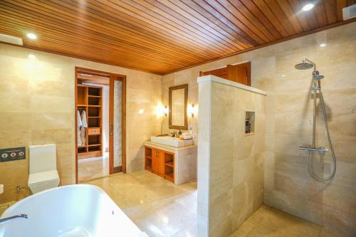 a bathroom with a tub and a shower and a sink at The Allure Ubud Villas & Spa crafted by freshWater Asia in Ubud