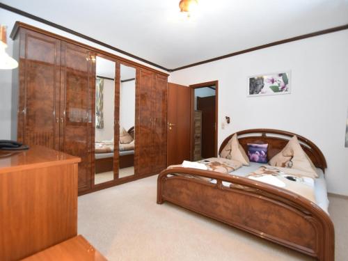1 dormitorio con cama de madera y vestidor en Luxurious Apartment in Jägersgrün with Saunas, en Jägersgrün