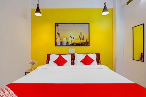 a bedroom with a bed with red and yellow walls at Hotel O Parppidam Residency Kazhakuttam Railway Station in Kazhakuttam
