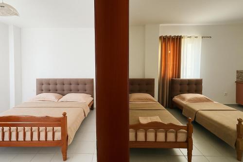 a bedroom with two beds and a mirror at Hotel Ardian in Golem