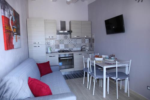 a kitchen with a table with chairs and a couch at Casa Alice in Syracuse