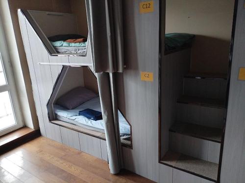 a small room with a bunk bed and a mirror at Guest House Ulaanbaatar in Ulaanbaatar
