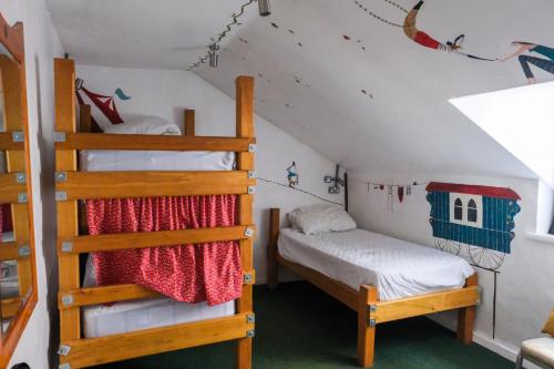 a bedroom with two bunk beds and a ladder at The Full Moon Backpackers in Bristol