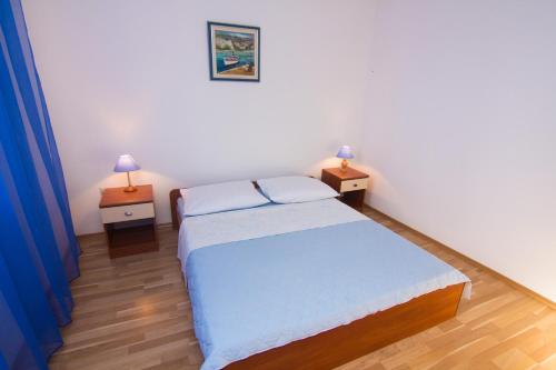a bedroom with a bed and two night stands with lamps at Apartment Magdic in Brzac