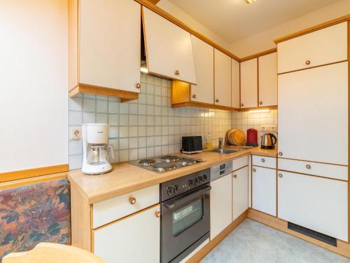 a kitchen with white cabinets and a stove top oven at Beautiful apartment in Mittersill with balcony in Mittersill