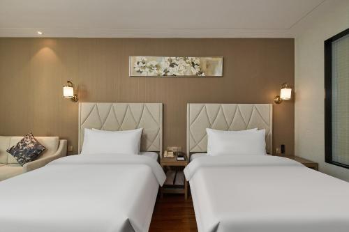 Postel nebo postele na pokoji v ubytování ARULA Youngor Central Hotel-Suzhou Guanqian St