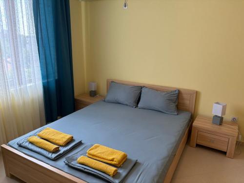 a bedroom with a bed with two towels on it at Cherno More Apartment in Ahtopol