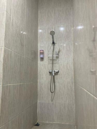 a shower with a shower head in a bathroom at Hotel Sanrina Kuta Bali in Kuta