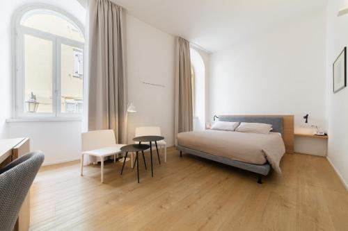 a bedroom with a bed and a table and chairs at Hotel Lago Di Garda in Nago-Torbole