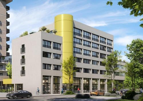 un bâtiment avec une tour jaune au sommet dans l'établissement Eklo Nantes Centre Ile de Nantes, à Nantes