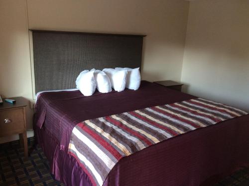 a hotel room with a bed with white pillows at Royal Inn in Tonawanda