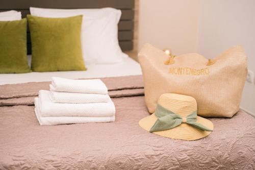 a hat and towels sitting on top of a bed at The Rooftop of Apartments Lungo Mare in Ulcinj